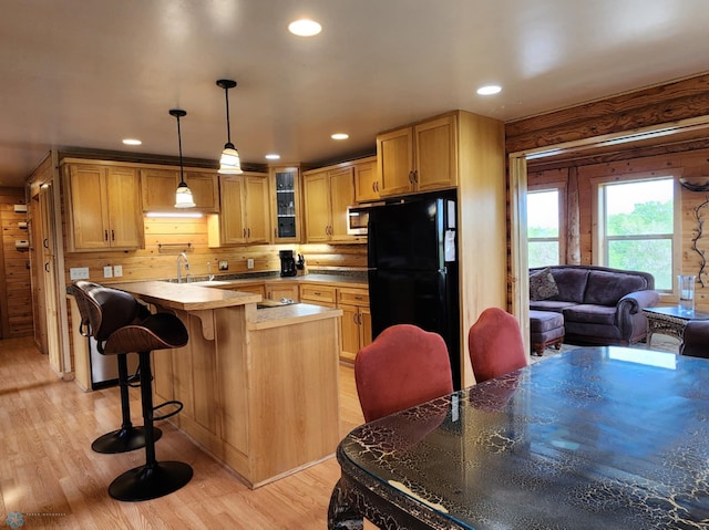 25712 15th Ave N, Highland Grove Twp, MN 56549 - kitchen featuring freestanding refrigerator, stainless steel microwave, glass insert cabinets, recessed lighting, and light wood-style floors
