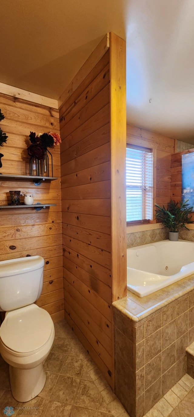 25712 15th Ave N, Highland Grove Twp, MN 56549 - full bathroom with a tub with jets, wooden walls, toilet, and tile patterned flooring