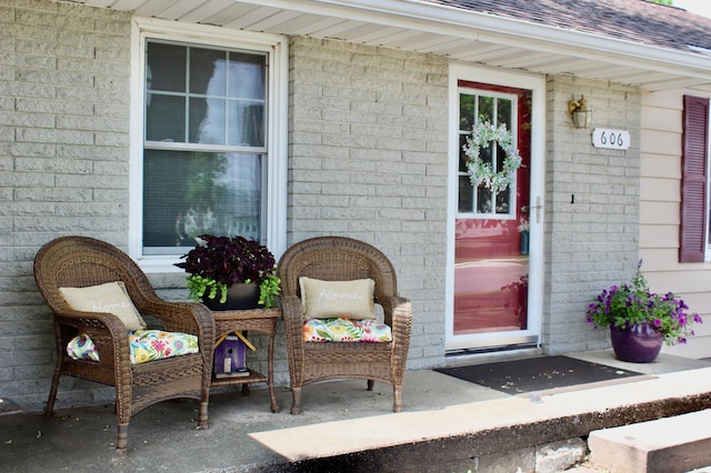 606 Center Ave N, Blooming Prairie, MN 55917 - doorway to property featuring brick siding and roof with shingles