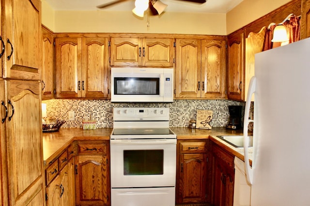 606 Center Ave N, Blooming Prairie, MN 55917 - kitchen featuring white appliances, decorative backsplash, a ceiling fan, and brown cabinets