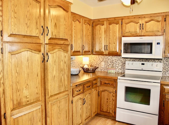 606 Center Ave N, Blooming Prairie, MN 55917 - kitchen with white appliances, decorative backsplash, light wood-style flooring, ceiling fan, and brown cabinetry