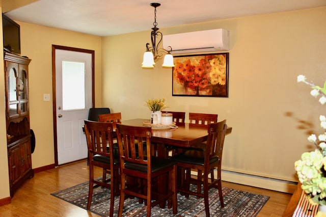606 Center Ave N, Blooming Prairie, MN 55917 - dining space featuring a wall mounted air conditioner, a baseboard heating unit, wood finished floors, and a chandelier