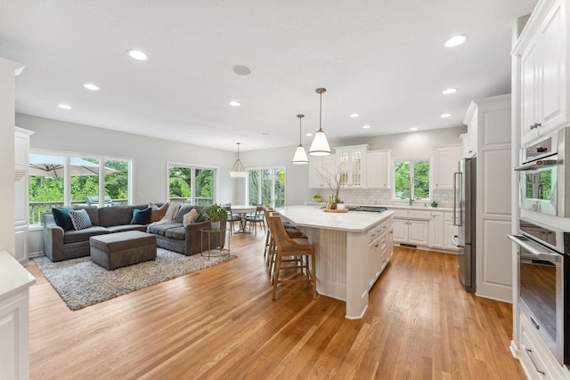 600 Sibley Ct, Mendota Heights, MN 55118 - kitchen with appliances with stainless steel finishes, open floor plan, healthy amount of natural light, light wood finished floors, and recessed lighting
