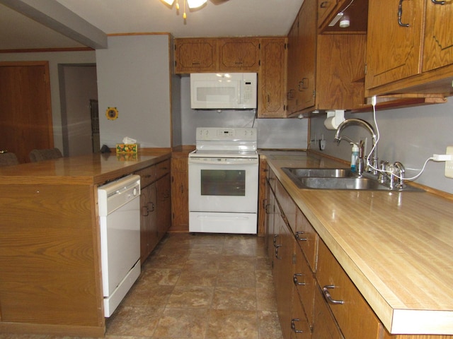 909 6th Ave, Brewster, MN 56119 - kitchen featuring white appliances, brown cabinets, a peninsula, a ceiling fan, and dark stone finish flooring