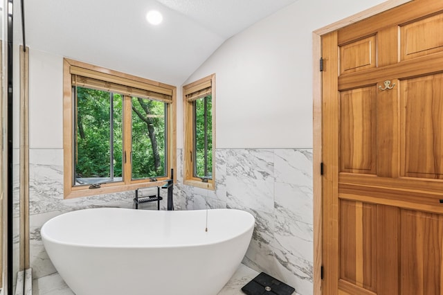 2665 Oriole Ave N, West Lakeland Twp, MN 55082 - bathroom with tile walls, marble finish floors, a wainscoted wall, vaulted ceiling, and a freestanding bath