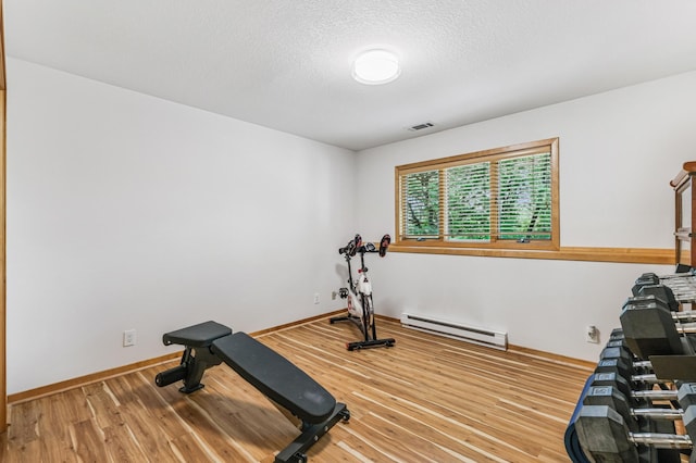 2665 Oriole Ave N, West Lakeland Twp, MN 55082 - exercise area with baseboard heating, light wood-type flooring, a textured ceiling, and baseboards
