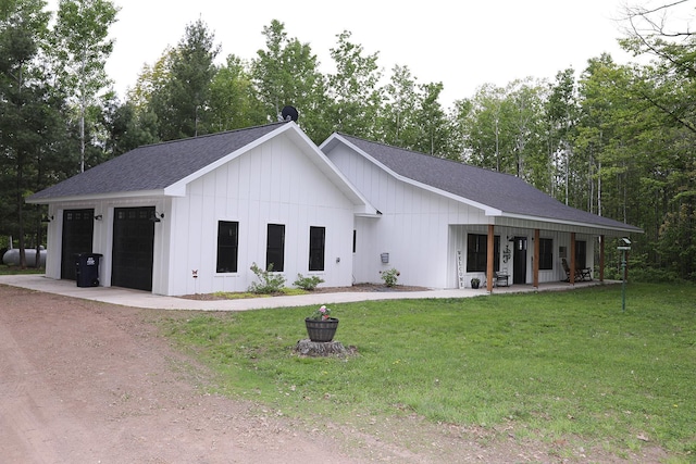 5004 W Rd, Silver Twp, MN 55767 - view of front of property with roof with shingles, board and batten siding, a garage, a front lawn, and covered porch