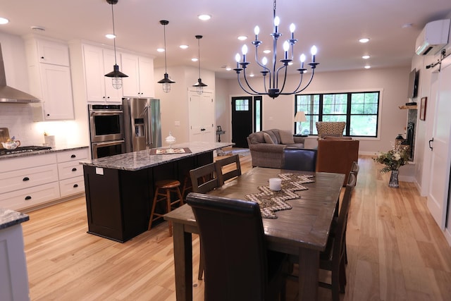 5004 W Rd, Silver Twp, MN 55767 - dining area featuring a wall mounted air conditioner, light wood-type flooring, recessed lighting, and a chandelier