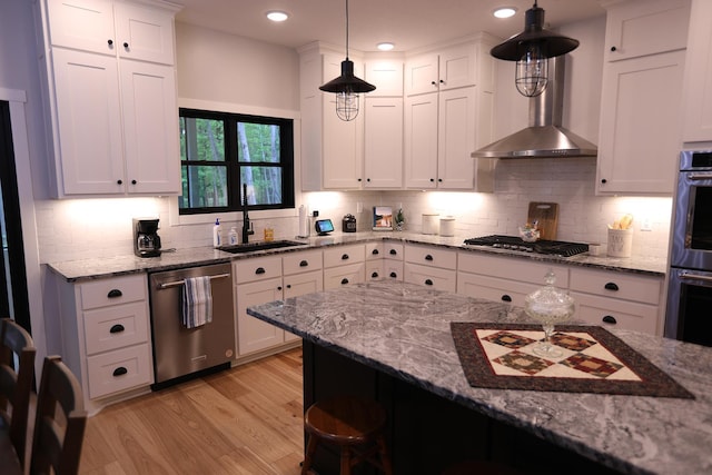 5004 W Rd, Silver Twp, MN 55767 - kitchen featuring appliances with stainless steel finishes, a kitchen bar, wall chimney range hood, light wood-type flooring, and a sink