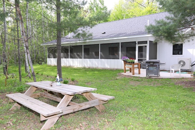 5004 W Rd, Silver Twp, MN 55767 - back of property with a sunroom, a patio area, a yard, and roof with shingles