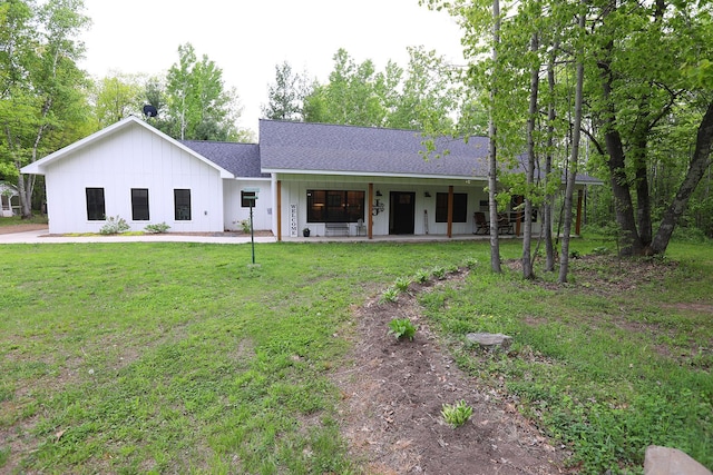 5004 W Rd, Silver Twp, MN 55767 - view of front of house featuring board and batten siding, a shingled roof, and a front yard