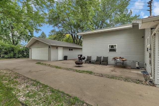 2007 8th St N, Saint Cloud, MN 56303 - view of patio / terrace featuring an outdoor structure, a detached garage, and an outdoor fire pit