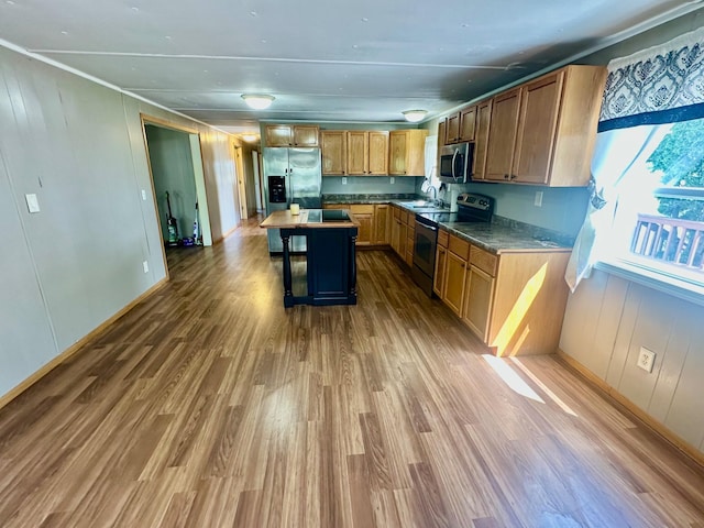 15373 Shawn St, Rocksbury Twp, MN 56701 - kitchen featuring appliances with stainless steel finishes, wood finished floors, a kitchen island, baseboards, and crown molding