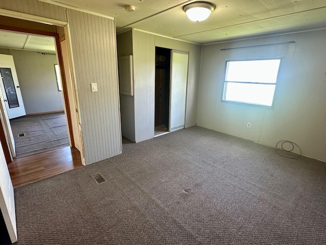 15373 Shawn St, Rocksbury Twp, MN 56701 - unfurnished bedroom with carpet, a closet, crown molding, and wood finished floors