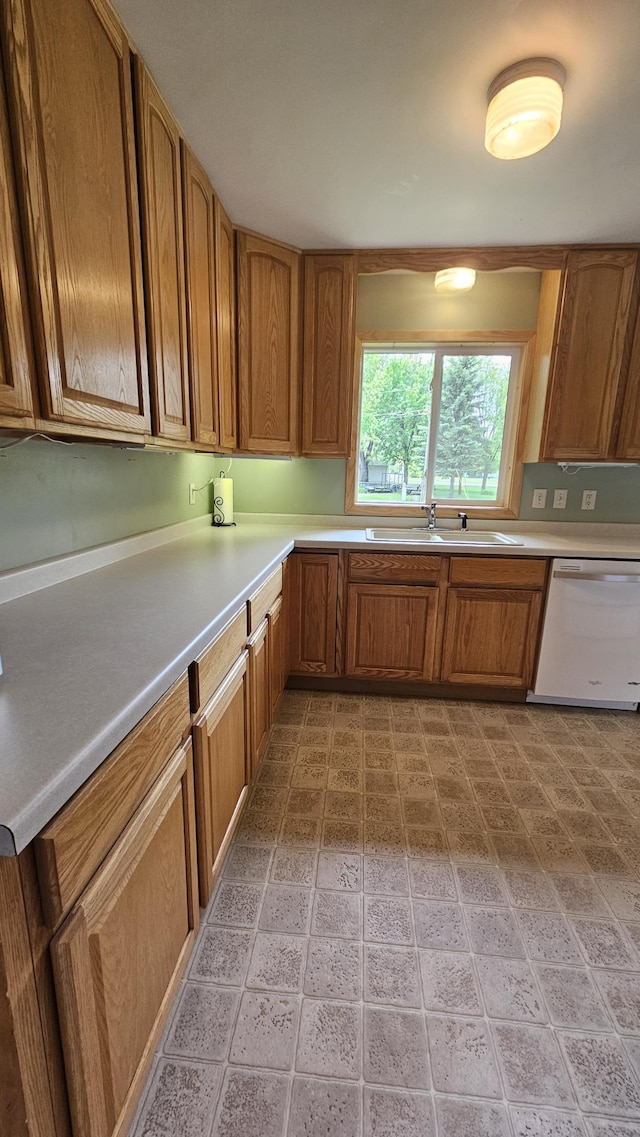 1309 Elm Ave N, Wheaton, MN 56296 - kitchen with dishwasher, light countertops, brown cabinetry, and a sink