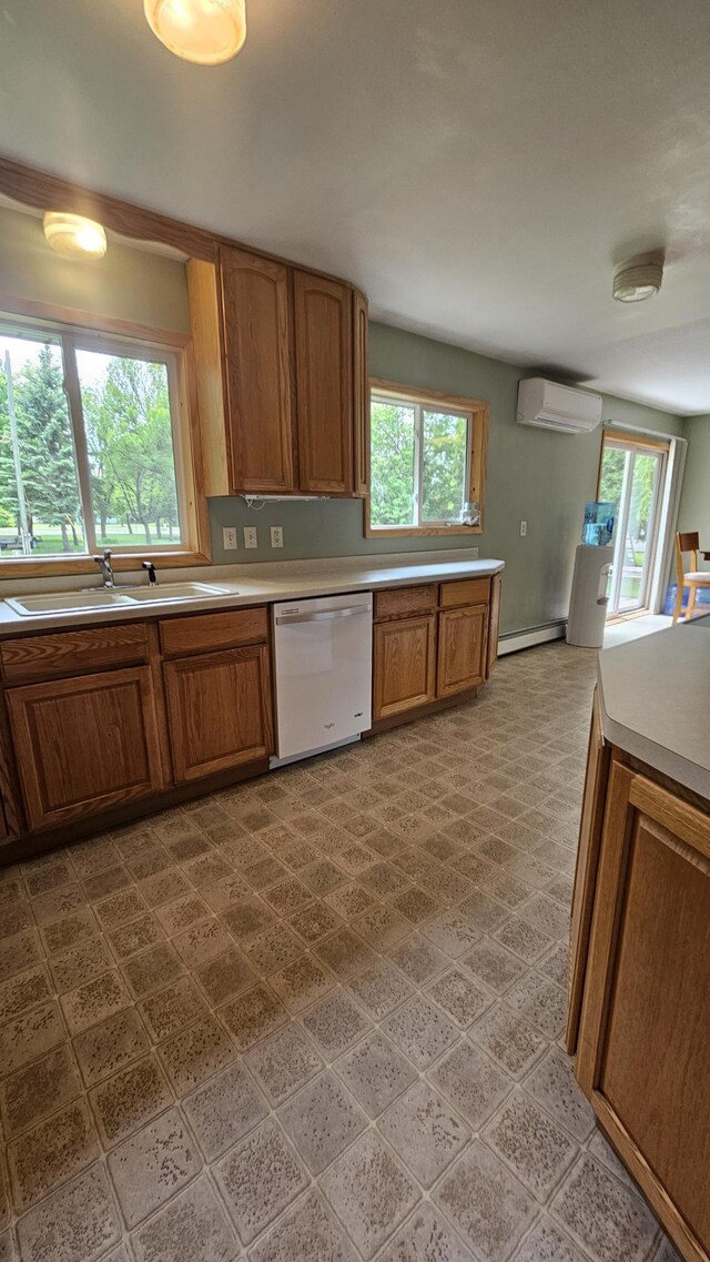 1309 Elm Ave N, Wheaton, MN 56296 - kitchen with white dishwasher, a sink, baseboard heating, a wall mounted AC, and brown cabinets