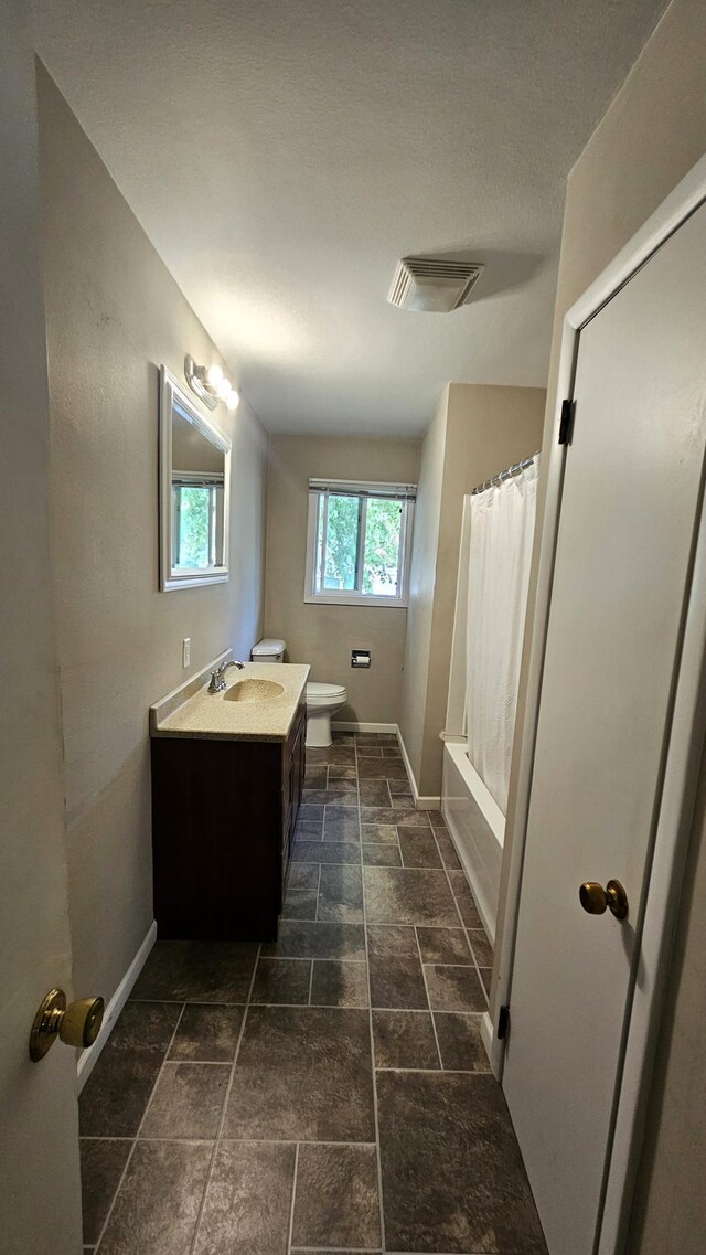 1309 Elm Ave N, Wheaton, MN 56296 - full bathroom featuring vanity, toilet, baseboards, and stone finish floors