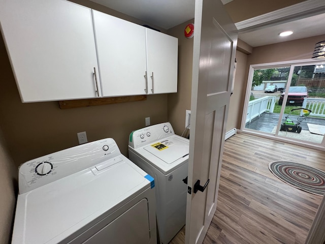 975 4th St E, Saint Paul, MN 55106 - washroom featuring washing machine and clothes dryer, light wood-style flooring, cabinet space, and baseboards