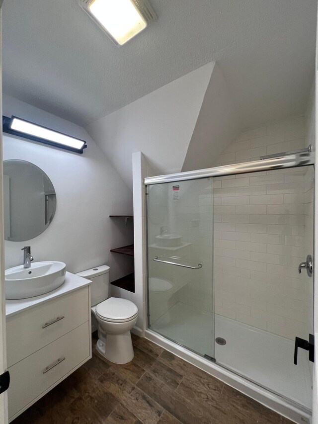 975 4th St E, Saint Paul, MN 55106 - full bath with toilet, a shower stall, vanity, vaulted ceiling, and wood finished floors