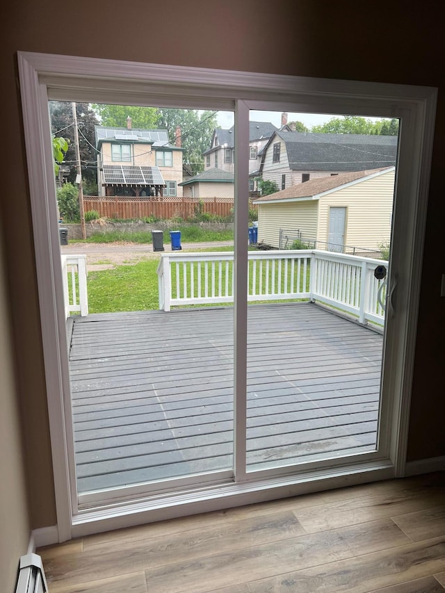 975 4th St E, Saint Paul, MN 55106 - doorway to outside with a baseboard radiator and wood finished floors