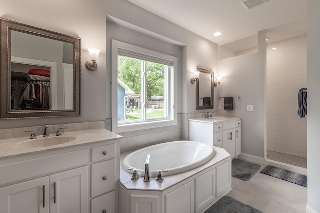 2105 7th Ave S, Saint Cloud, MN 56301 - bathroom with two vanities, a tile shower, a garden tub, tile patterned flooring, and baseboards