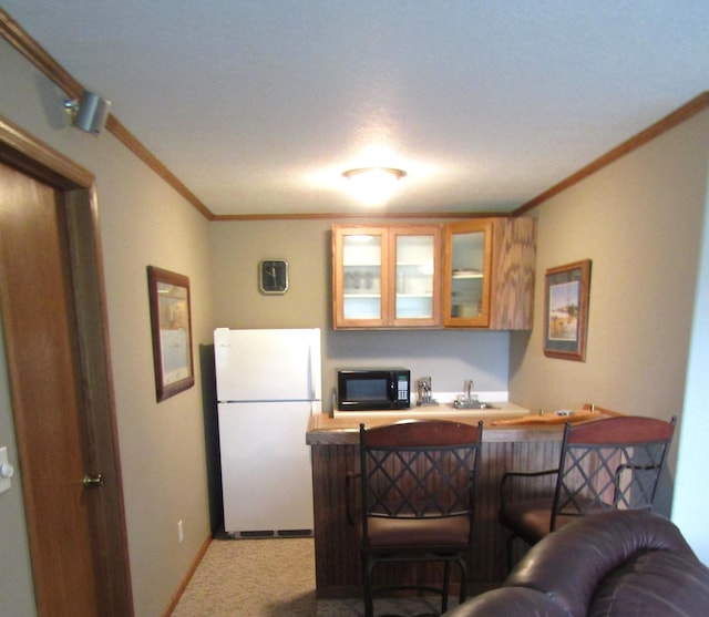180 Bordson St, Appleton, MN 56208 - kitchen featuring freestanding refrigerator, black microwave, carpet, glass insert cabinets, and crown molding