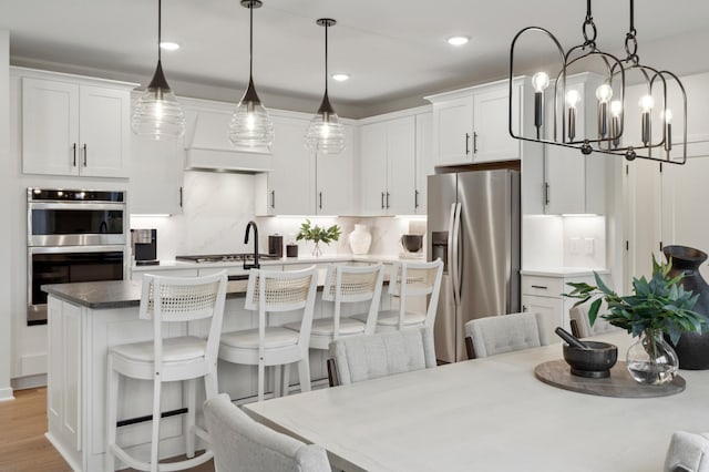 14625 105th Pl N, Maple Grove, MN 55369 - kitchen featuring appliances with stainless steel finishes, a kitchen island with sink, white cabinets, a breakfast bar, and recessed lighting