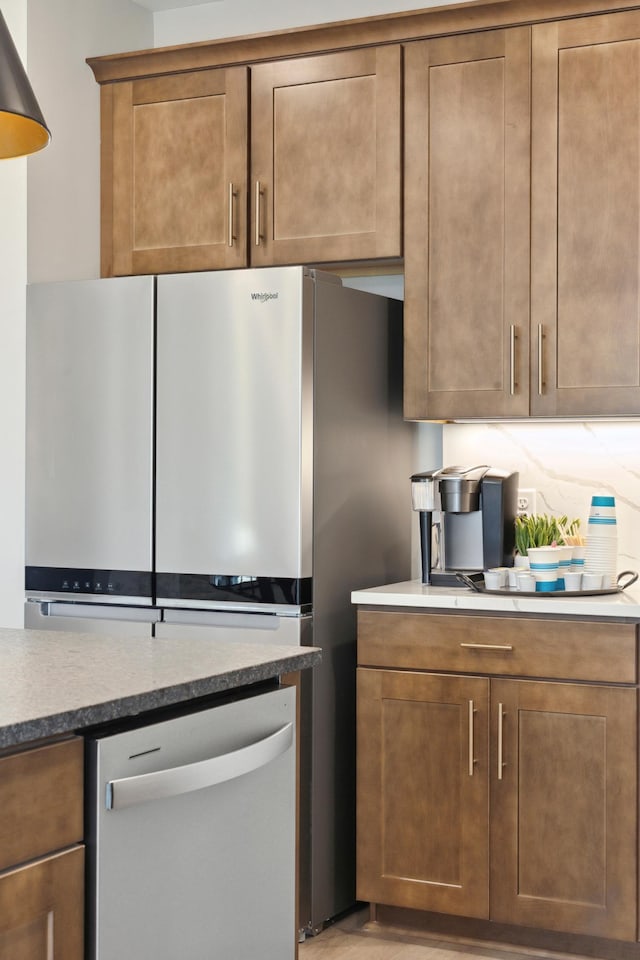 10635 Ithaca Ln N, Maple Grove, MN 55369 - kitchen with dishwashing machine, brown cabinets, and freestanding refrigerator