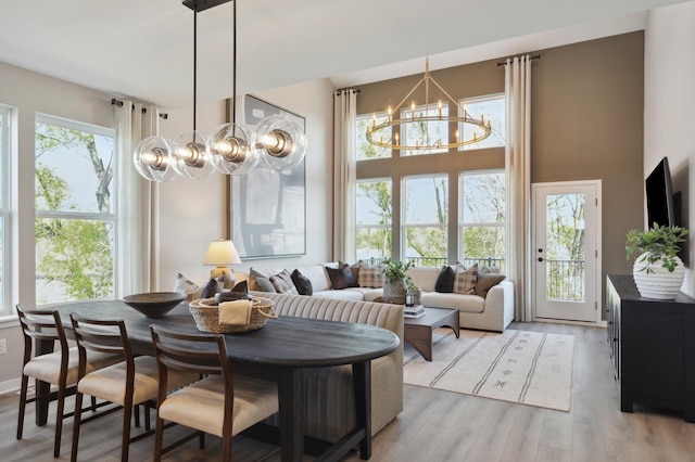 10635 Ithaca Ln N, Maple Grove, MN 55369 - dining space with a chandelier, light wood finished floors, and a high ceiling