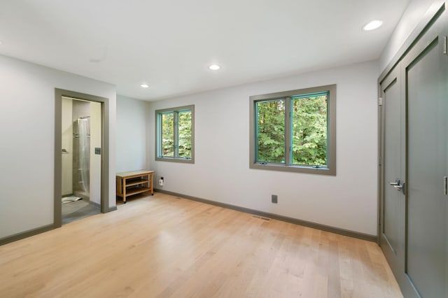 N7775 920th St, River Falls, WI 54022 - unfurnished bedroom featuring light wood-style flooring, recessed lighting, ensuite bathroom, and a closet