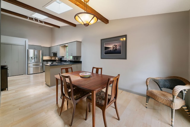 N7775 920th St, River Falls, WI 54022 - dining area featuring a skylight, beamed ceiling, light wood-style flooring, and high vaulted ceiling