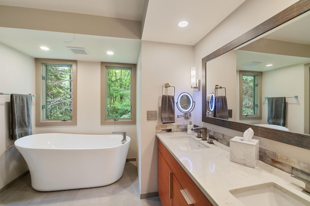 N7775 920th St, River Falls, WI 54022 - bathroom featuring a freestanding bath, double vanity, tile patterned flooring, and recessed lighting