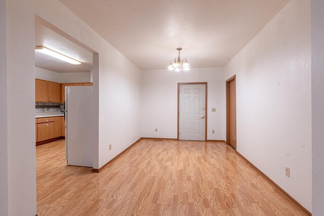 475 Minnehaha Ave E, Saint Paul, MN 55130 - unfurnished room featuring light wood finished floors, a chandelier, and baseboards