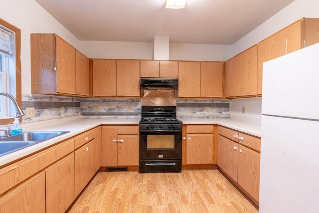 475 Minnehaha Ave E, Saint Paul, MN 55130 - kitchen with freestanding refrigerator, black gas range oven, a sink, light wood-style flooring, and light countertops