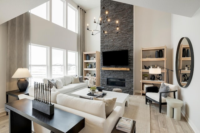 14705 105th Pl N, Maple Grove, MN 55369 - living room featuring a fireplace, a high ceiling, baseboards, and light wood-style flooring