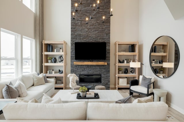 14705 105th Pl N, Maple Grove, MN 55369 - living area with a fireplace, a towering ceiling, healthy amount of natural light, wood finished floors, and baseboards