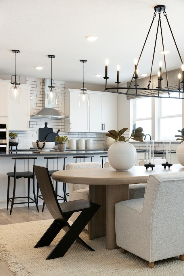 14705 105th Pl N, Maple Grove, MN 55369 - kitchen featuring decorative backsplash, wall chimney exhaust hood, white cabinetry, and decorative light fixtures