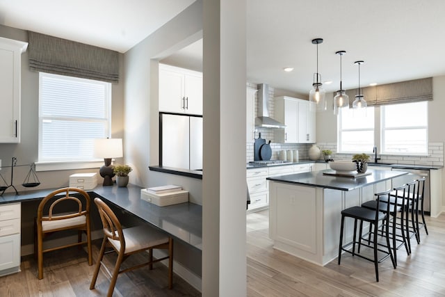 14705 105th Pl N, Maple Grove, MN 55369 - kitchen with wall chimney exhaust hood, dark countertops, a breakfast bar, stainless steel gas cooktop, and dishwashing machine