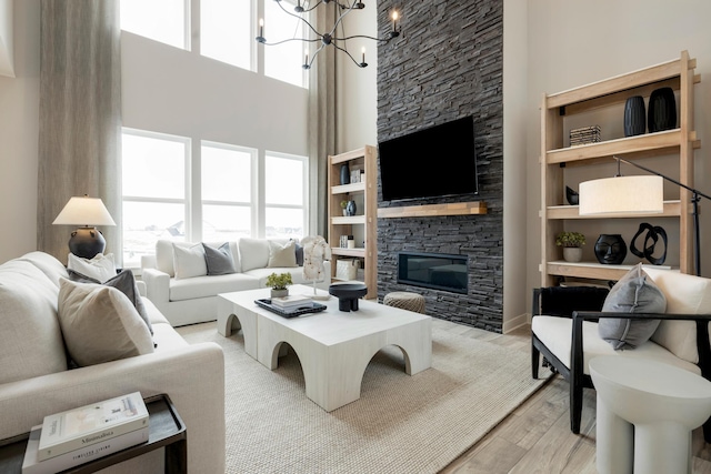 14705 105th Pl N, Maple Grove, MN 55369 - living area featuring a towering ceiling, a fireplace, light wood-type flooring, and a chandelier