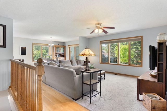 2800 9th Ave SW, Austin, MN 55912 - living room featuring a ceiling fan, a chandelier, baseboards, and a textured ceiling