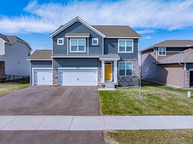 830 Foxglove Ter, Waconia, MN 55387 - view of front of home featuring driveway, stone siding, an attached garage, and roof with shingles