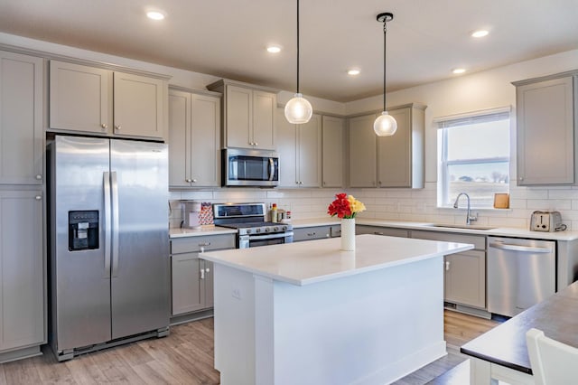 830 Foxglove Ter, Waconia, MN 55387 - kitchen with appliances with stainless steel finishes, a sink, gray cabinetry, light wood-style floors, and tasteful backsplash