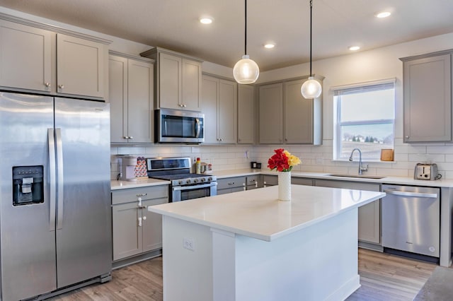 830 Foxglove Ter, Waconia, MN 55387 - kitchen with appliances with stainless steel finishes, gray cabinets, a sink, light wood-style floors, and tasteful backsplash
