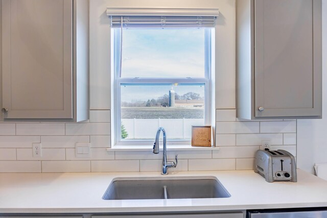 830 Foxglove Ter, Waconia, MN 55387 - kitchen featuring a sink, gray cabinets, dishwashing machine, and tasteful backsplash