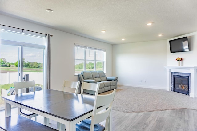 830 Foxglove Ter, Waconia, MN 55387 - dining room with wood finished floors, a textured ceiling, a fireplace, recessed lighting, and baseboards