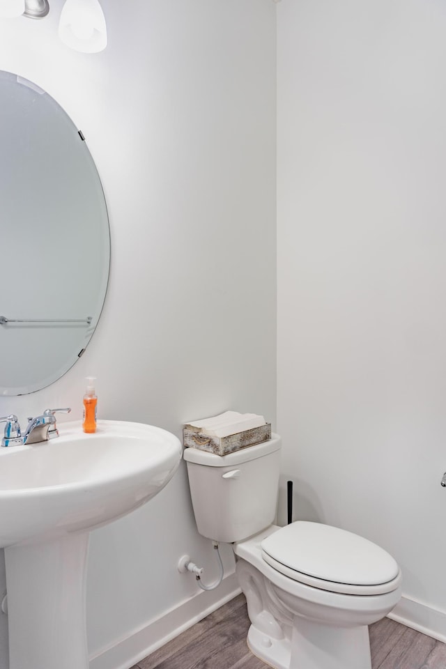 830 Foxglove Ter, Waconia, MN 55387 - half bath featuring wood finished floors, toilet, baseboards, and a sink