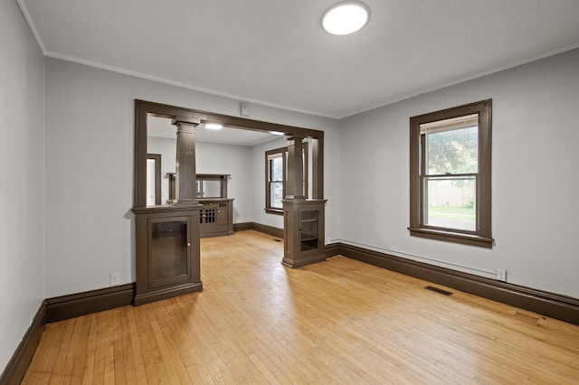 3400 Elliot Ave S, Minneapolis, MN 55407 - spare room with ornate columns, healthy amount of natural light, light wood-style floors, crown molding, and baseboards