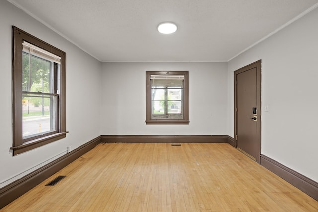 3400 Elliot Ave S, Minneapolis, MN 55407 - spare room with light wood-style floors, baseboards, and crown molding