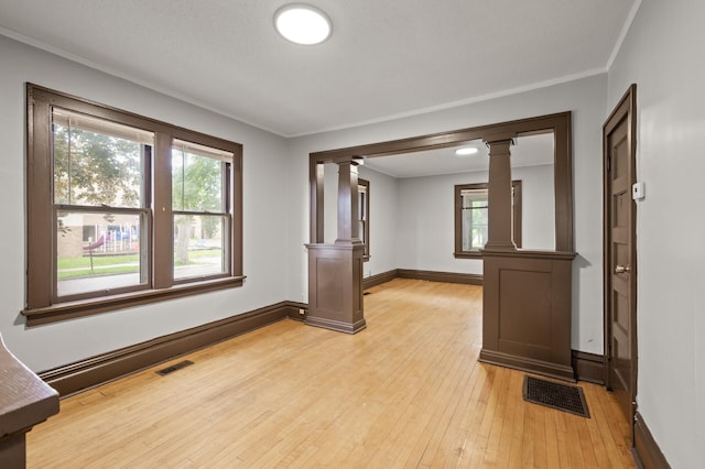 3400 Elliot Ave S, Minneapolis, MN 55407 - unfurnished room featuring decorative columns, light wood-style floors, baseboards, and crown molding