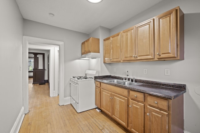 3400 Elliot Ave S, Minneapolis, MN 55407 - kitchen featuring white range with gas stovetop, a sink, dark countertops, and baseboards
